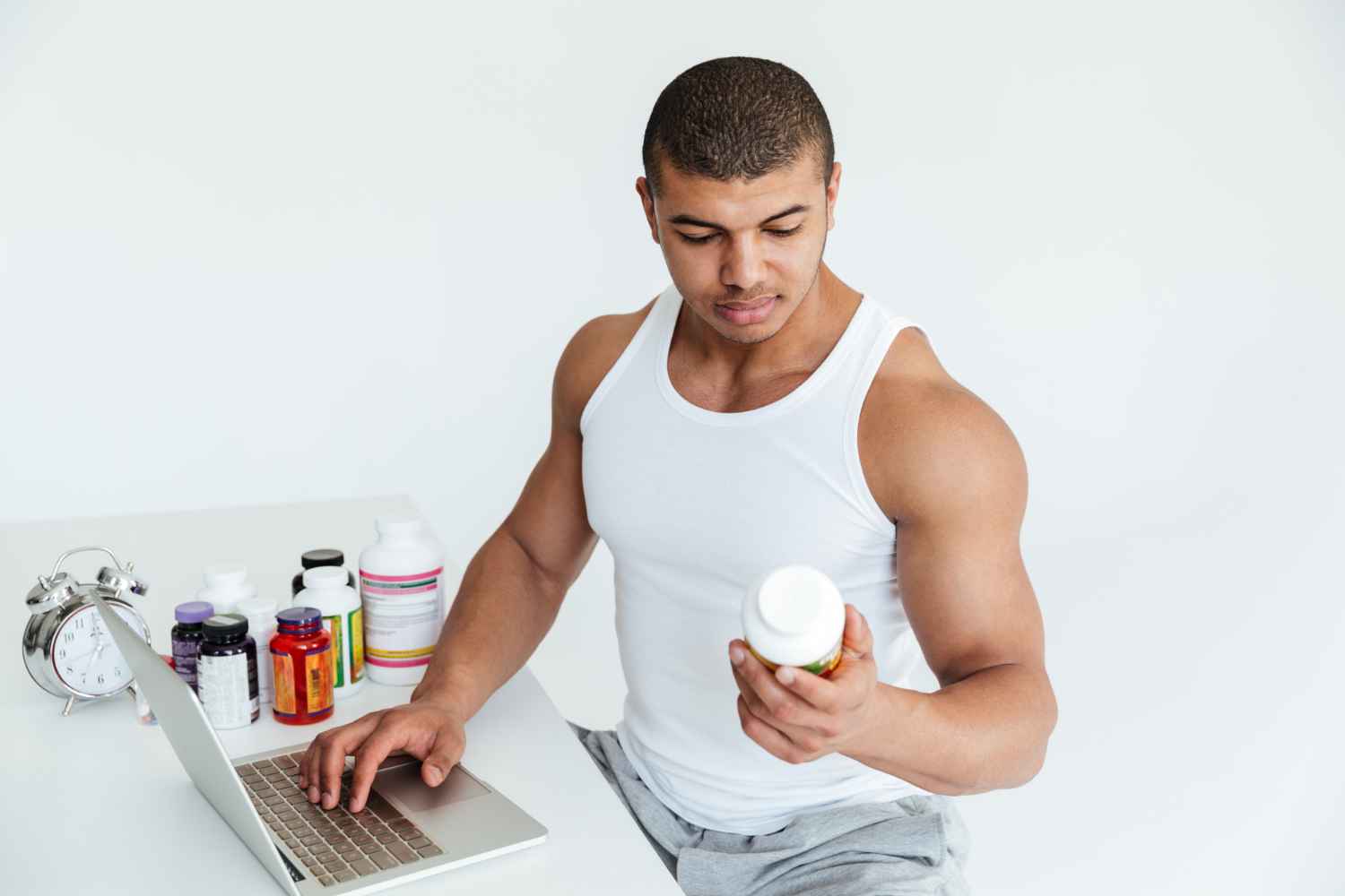 handsome-young-sportsman-holding-sport-nutrition-using-laptop-computer_11zon